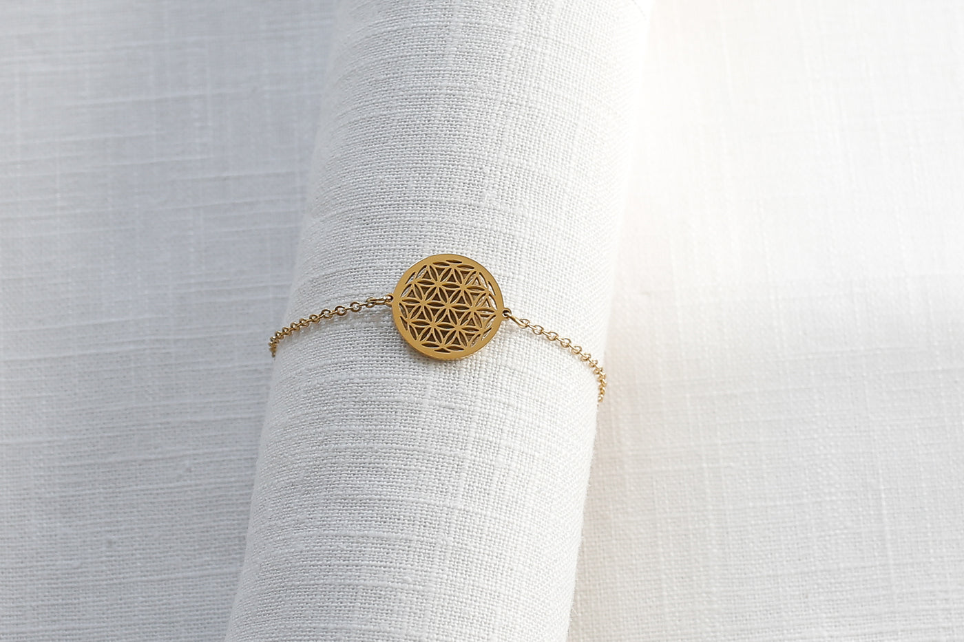 Zeitloses Mandala Armband mit verstellbarem Verschluss in Gold auf Stoff