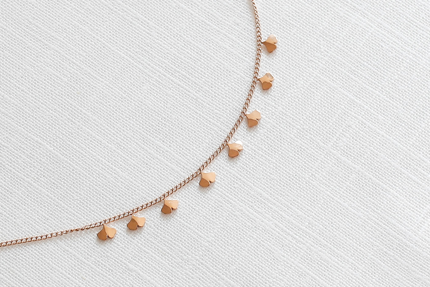 Minimalistisches Armband mit Ginko Blatt Anhängern und extender Verschluss in Rosegold auf Stoff