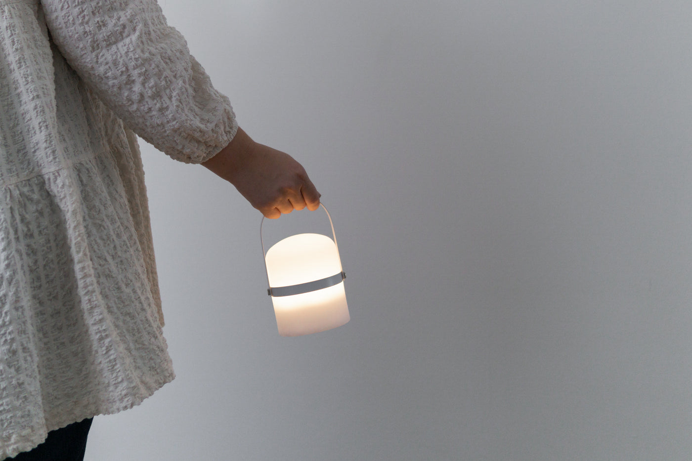 Frau hält moderne LED Laterne in klein am Holz Griff in weiß