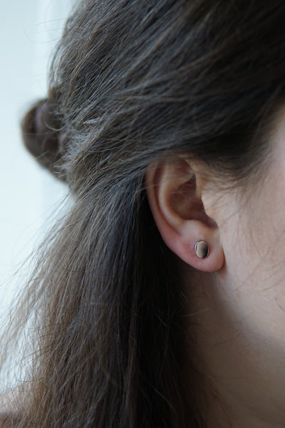 Junge Frau trägt ovale Plättchen Ohrringe im klassischen Stil 