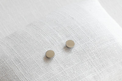 Plättchen Ohrringe in Silber auf Stoff platziert