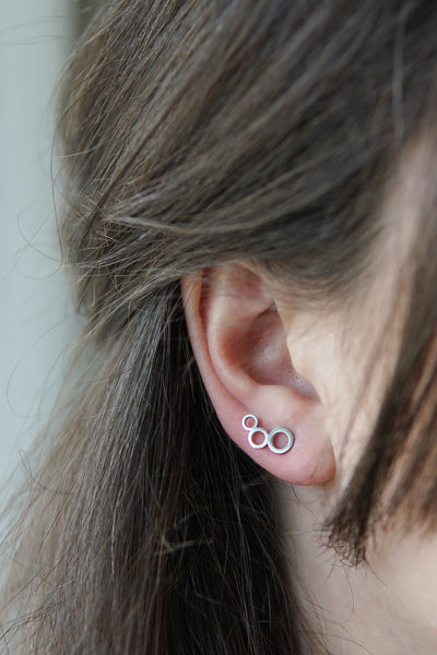 Verlängerte Ohrstecker in Silber mit drei unterschiedlich großen Ringen
