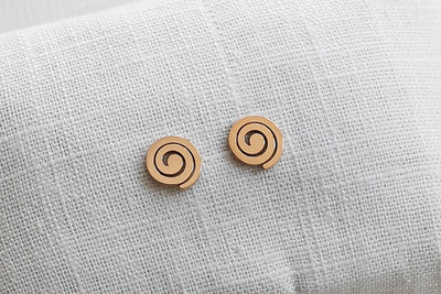 Rosa farbene Ohrringe mit Spiralen Stecker auf Stoff