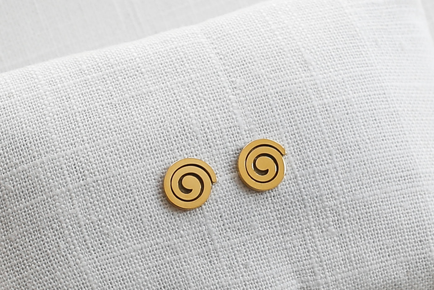 Kreisförmige Ohrringe in Gold auf Stoff