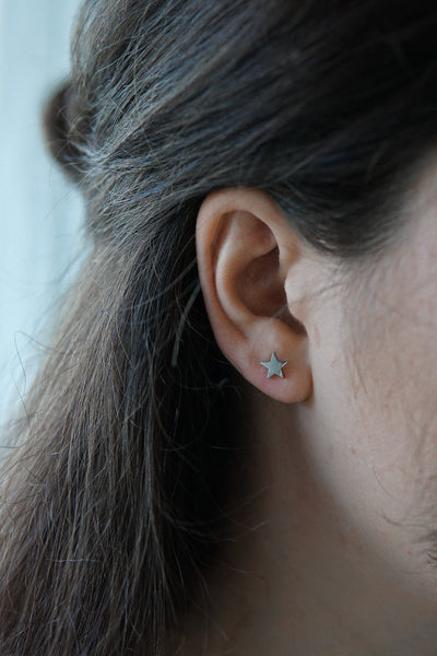 Junge Dame trägt silberne Stern Ohrstecker aus Edelstahl 