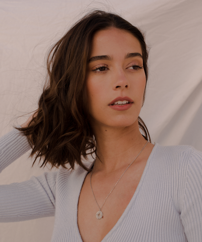 Mädchen trägt feine silberne Kette mit Kompass ANhänger im minimalistischen Stil 