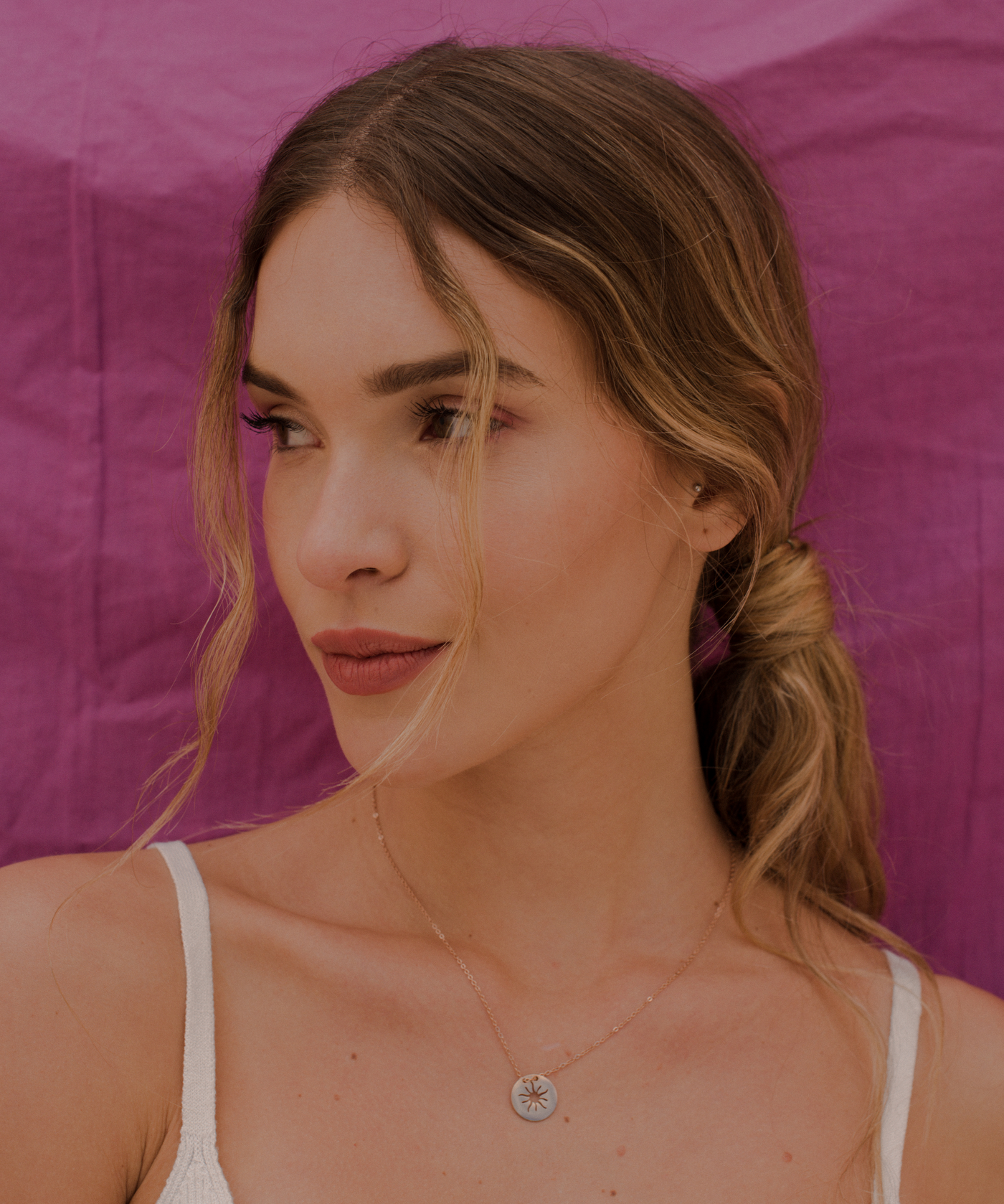 Junge Dame trägt Rose farbene Kette mit Sonnen Anhänger im Boho Stil