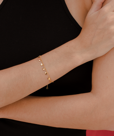 Frau trägt Armband aus Edelstahl vergoldet mit Ginkgo Anhängern am Handgelenk