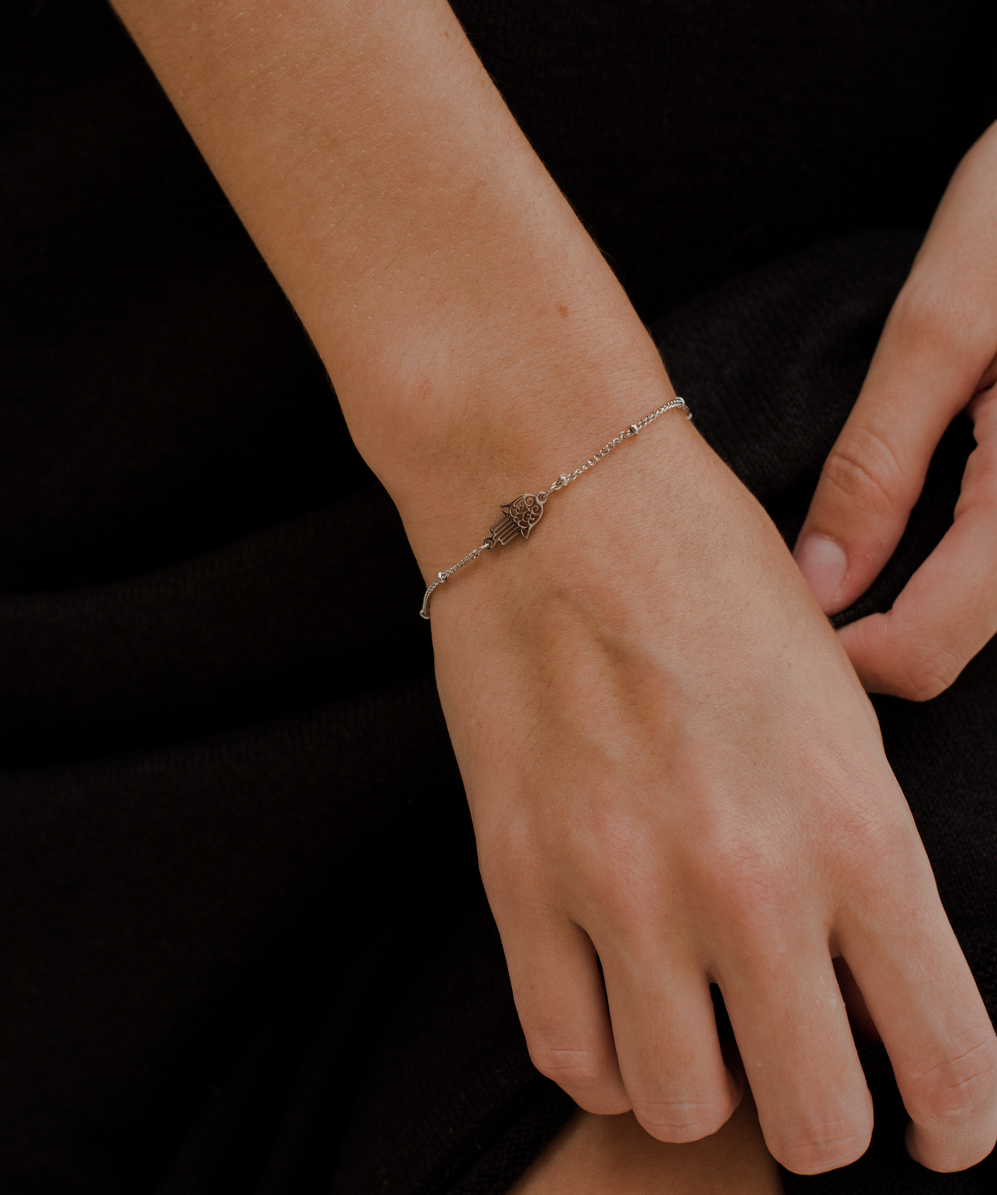 Mädchen trägt dezentes Edelstahl Armband mit Hand Anhänger