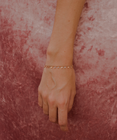 Filigranes Armband mit Mond Anhängern in Rosegold aus Edelstahl vor Rosa Hintergrund