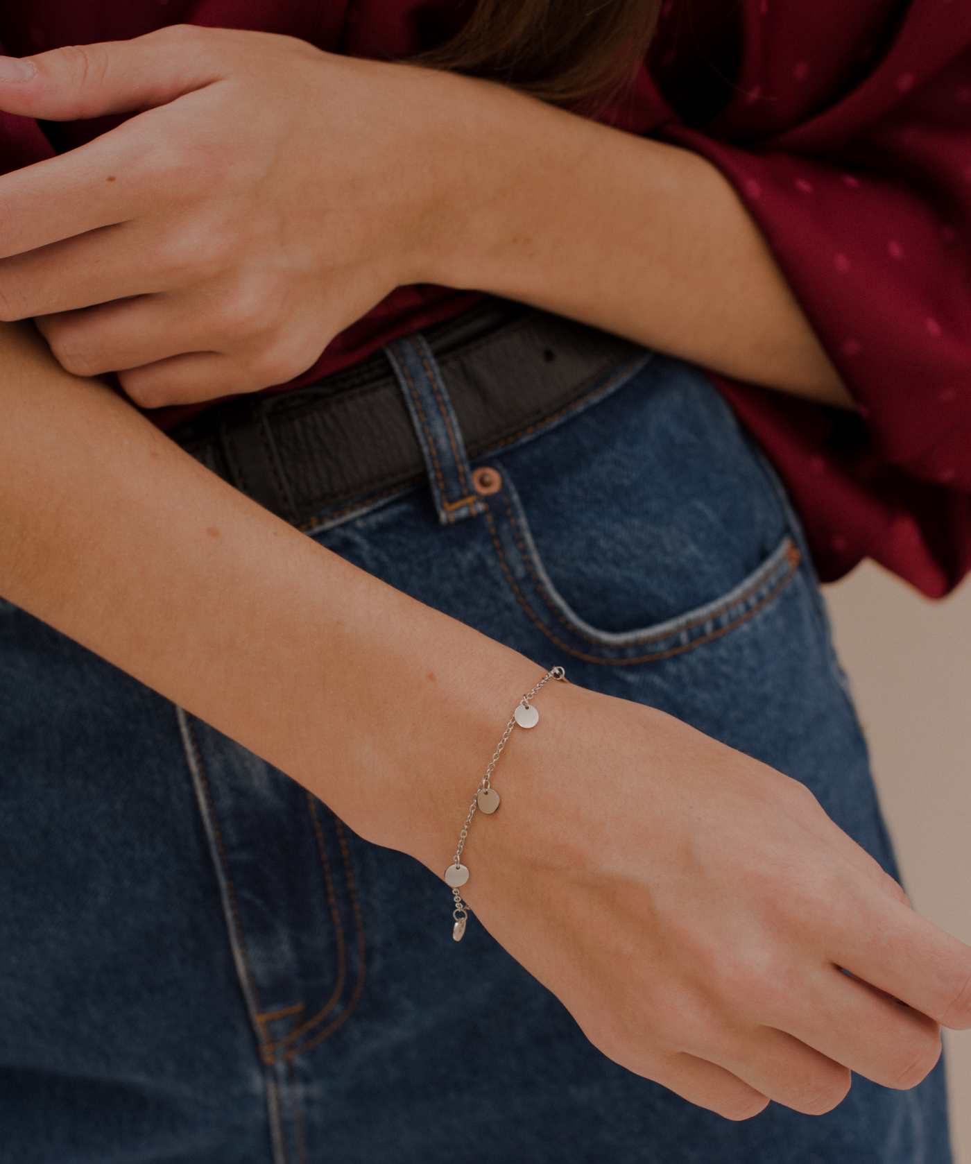 Junge Frau trägt ein schlichtes Coin Anhänger Armband aus Edelstahl 