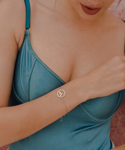  Frau trägt minimalistisches Armband mit Berg Anhänger aus Edelstahl.
