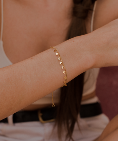 Frau trägt vergoldetes Armband aus Edelstahl mit kleinen Mond Anhängern