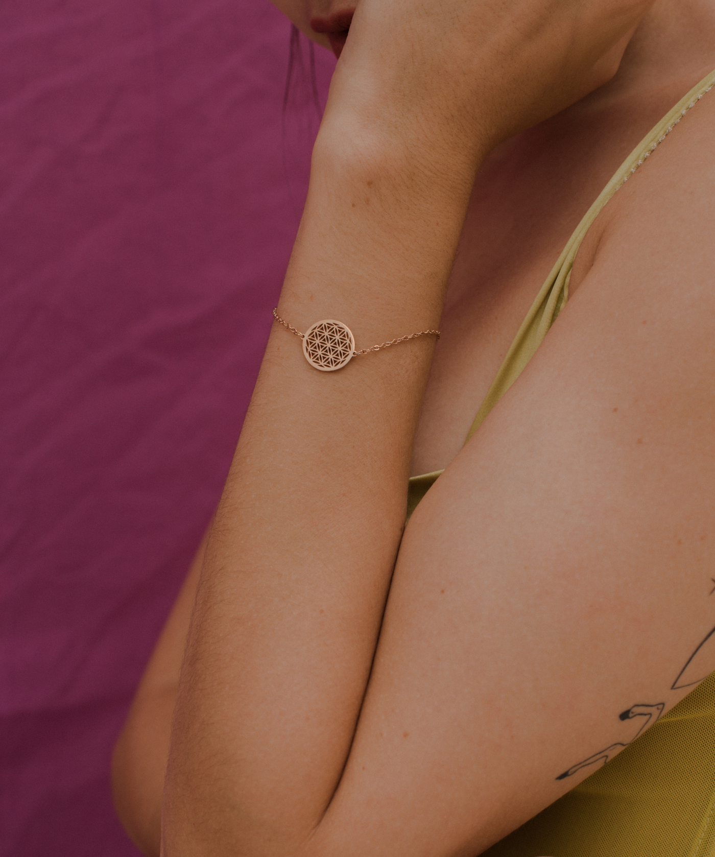 Dame trägt minimalistisches Armband mit Mandala Anhänger in Rosa 