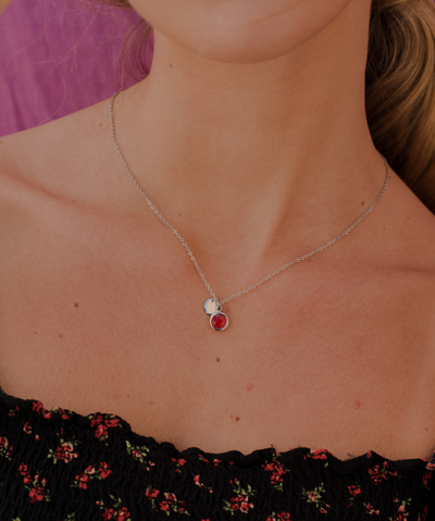 Damendekolletee trägt silberne edelstahl Halskette mit rotem Stein Anhänger