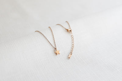 Minimalistische Halskette mit Stern Anhänger und Verlängerungsverschluss in Rosegold auf Stoff 