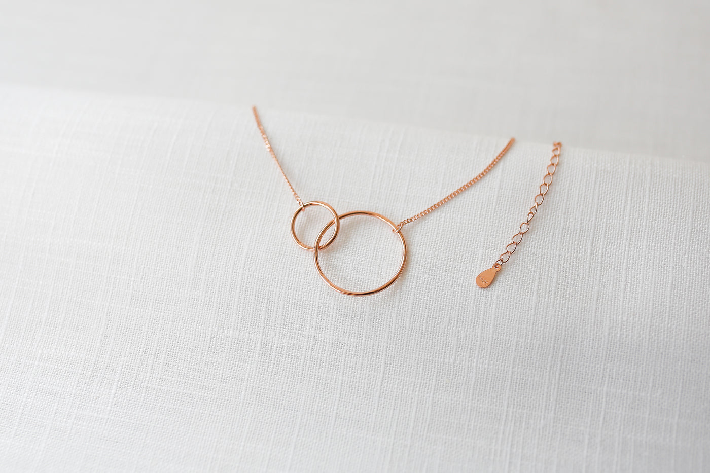 Kette mit geometrischen Anhängern und verlängerungs Verschluss in rosegold auf Stoff