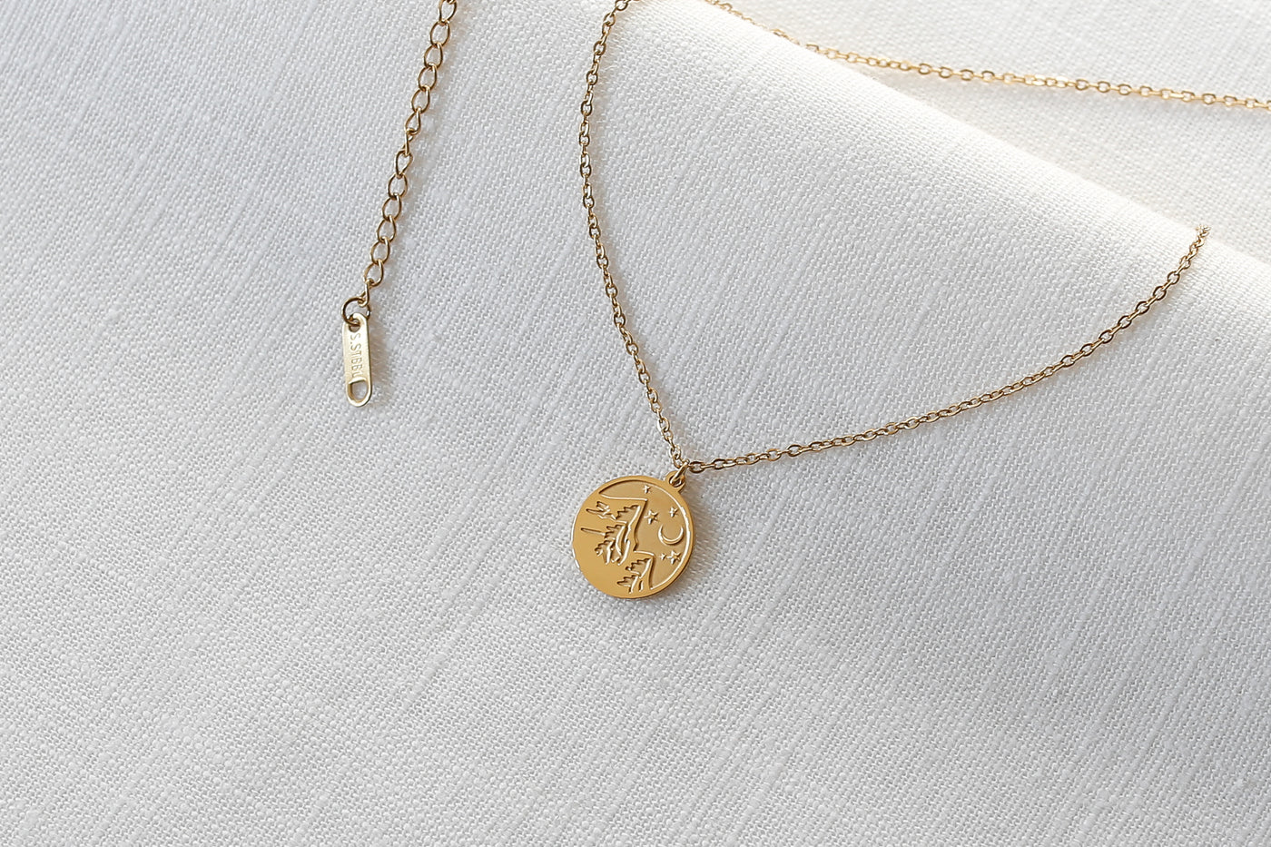 Kette mit Berg ANhänge rund verstellbarer Länge in gold platziert auf Leinen Stoff