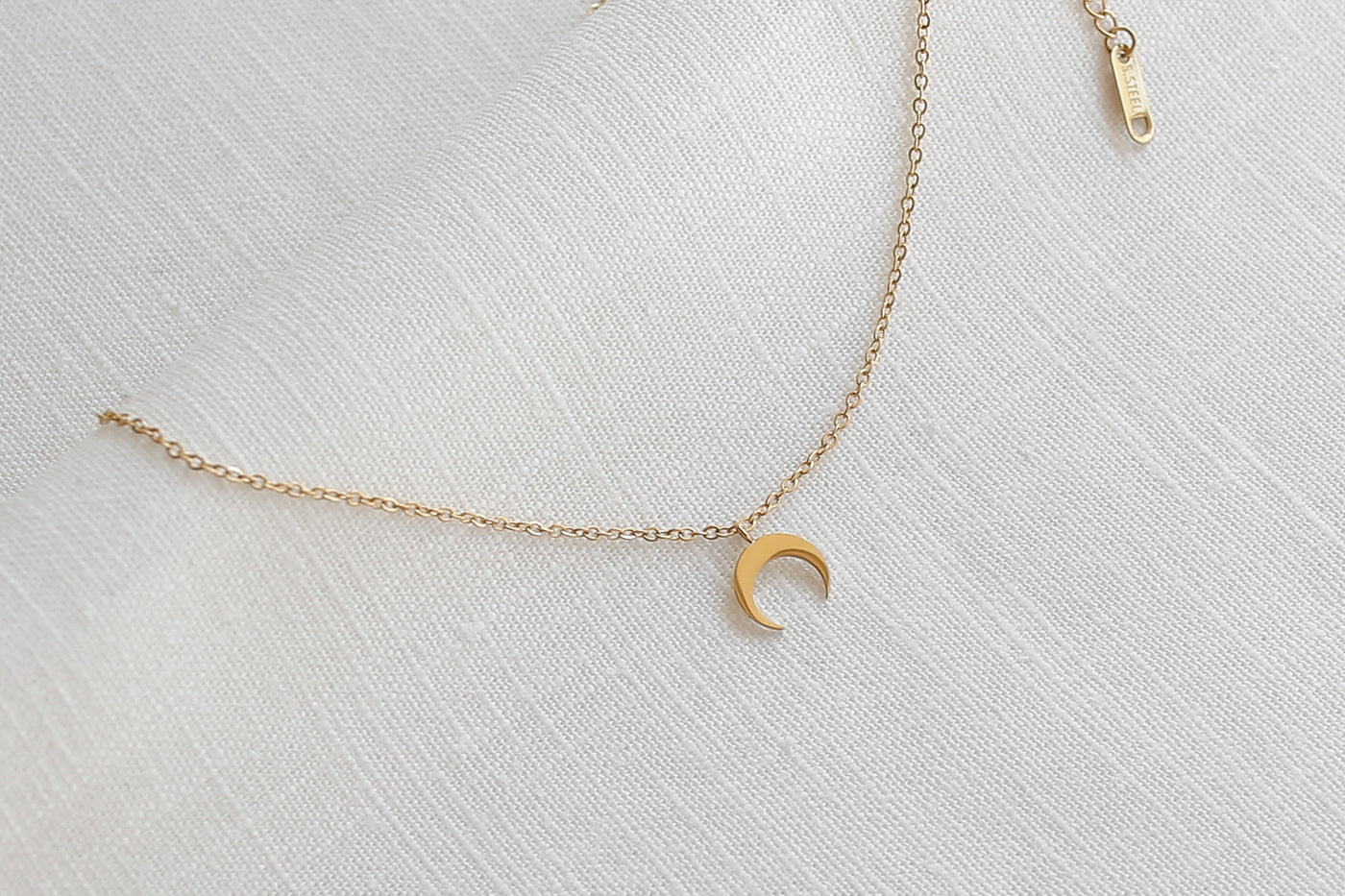 Kette mit Mond Anhänger und verstellbarer Länge in Gold auf Leinen Stoff