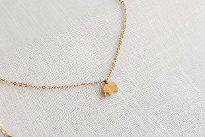 Kette mit Elefant Anhänger in Gold mit verstellbarer Länge auf Leinen Stoff