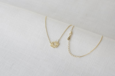 Vergoldete Halskette mit Lotus Anhänger und verstellbarer Verlängerungskette auf Leinen Tuch 