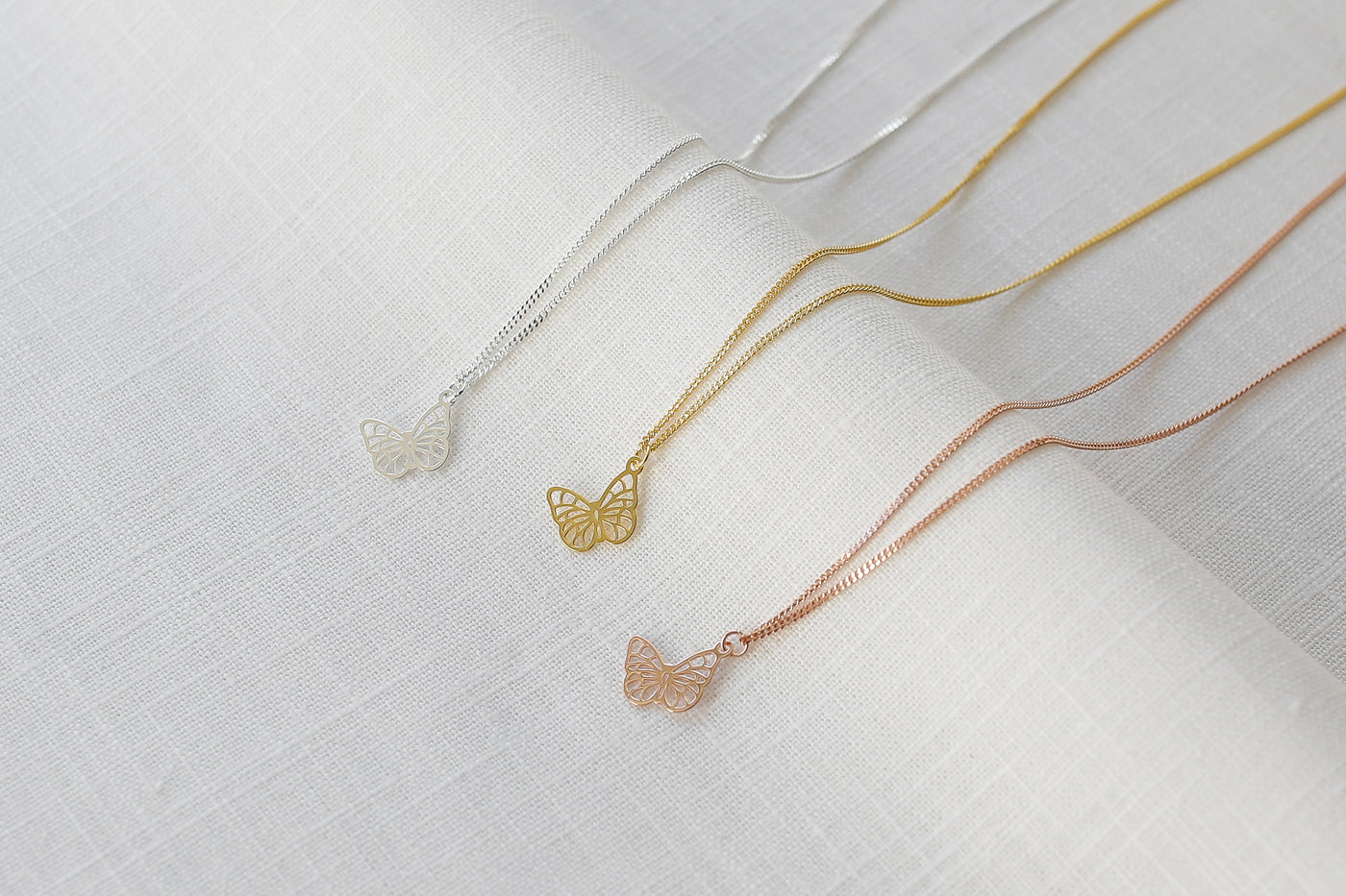 Drei verstellbare Halsketten mit Schmetterling Anhänger in Silber, Gold und Rosegold aus Sterling Silber 925 auf Stoff 