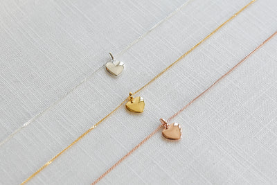 Drei alltagstaugliche Halsketten mit Herz Anhänger in jeweils Silber, Gold und Roségold auf Stoff