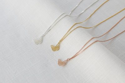 Drei verstellbare Halsketten mit Schmetterling Anhänger in Silber, Gold und Rosegold aus Sterling Silber 925 auf Stoff 