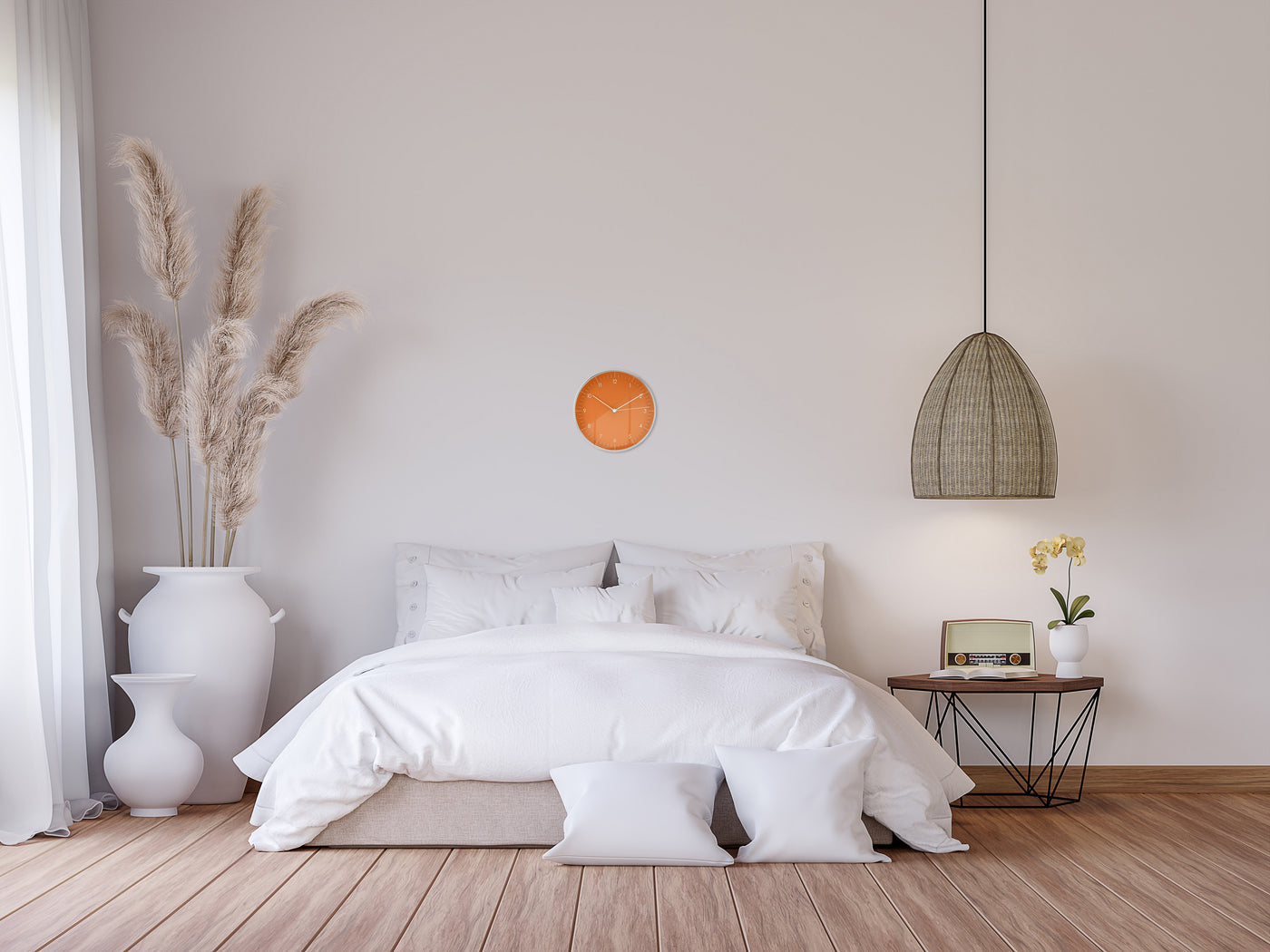 Orangene Wanduhr hängt über weißem Bett im Boho Stil 