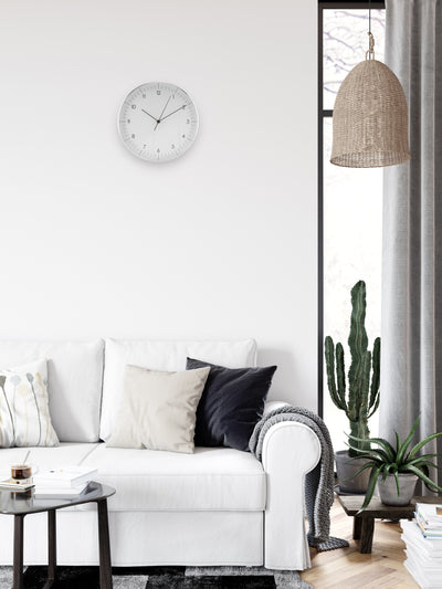 Wohnzimmer im Boho Stil mit moderner großer Wanduhr in Weiß und Silber