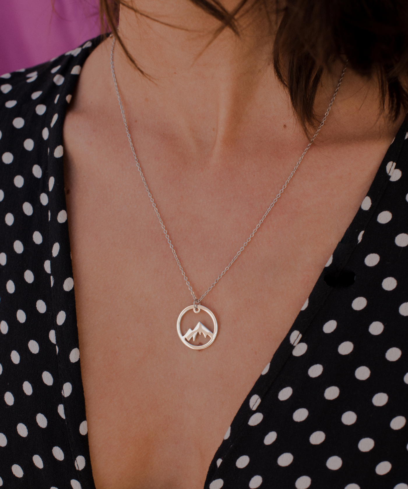  Frau trägt minimalistische Halskette mit Bergipfle Anhänger aus Edelstahl