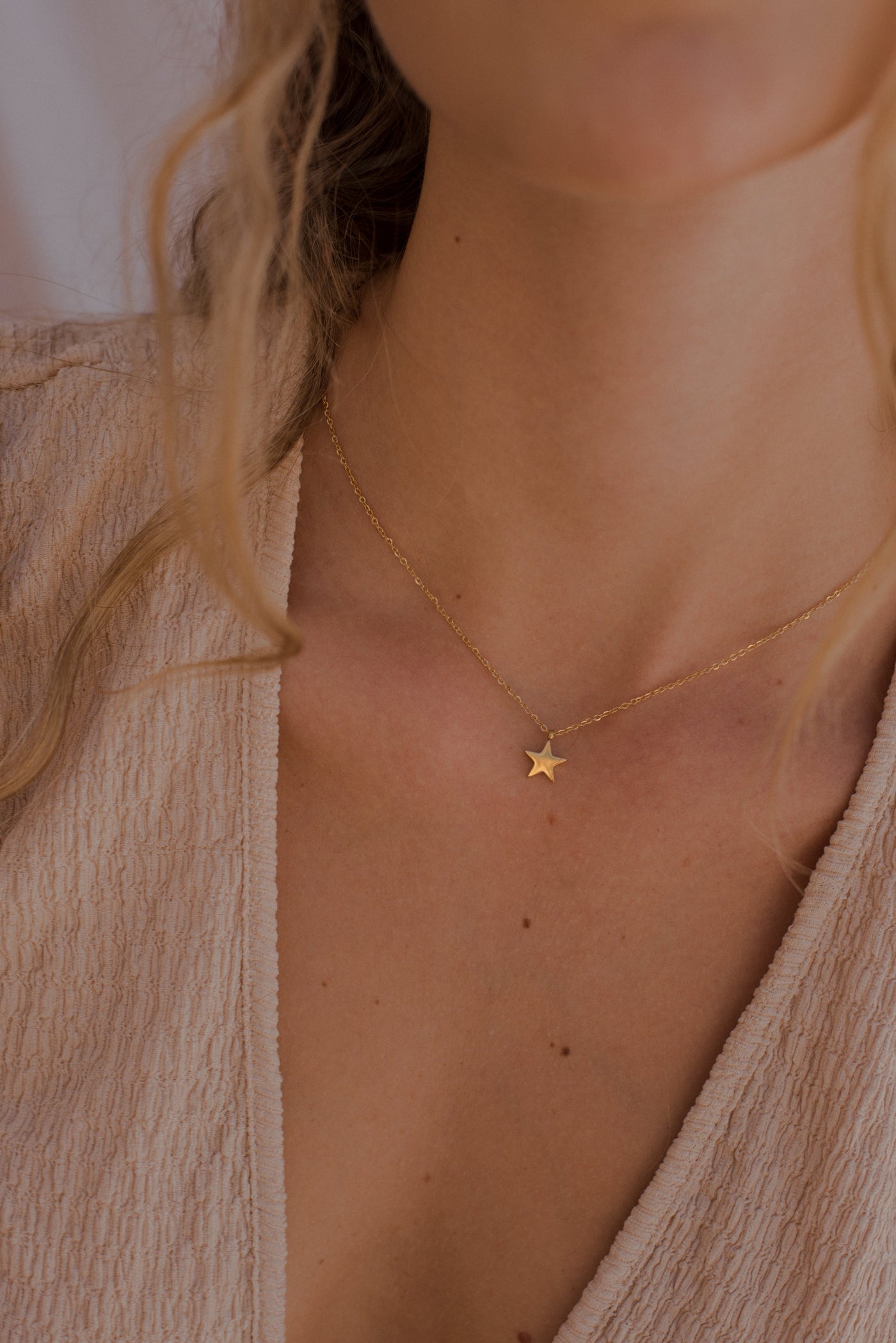 Frau trägt Halskette aus Edelstahl vergoldet mit Stern Anhänger 