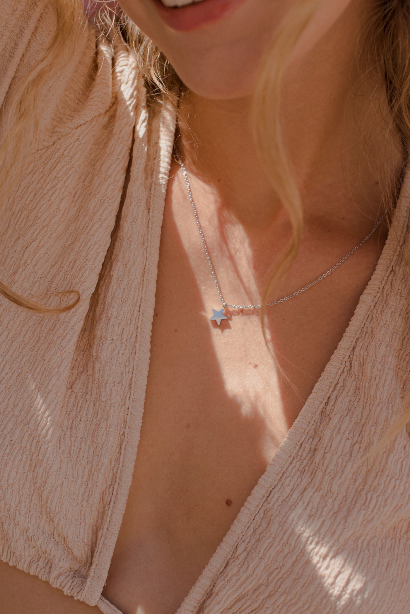 Frau trägt minimalistische Halskette mit Stern Anhänger in Edelstahl