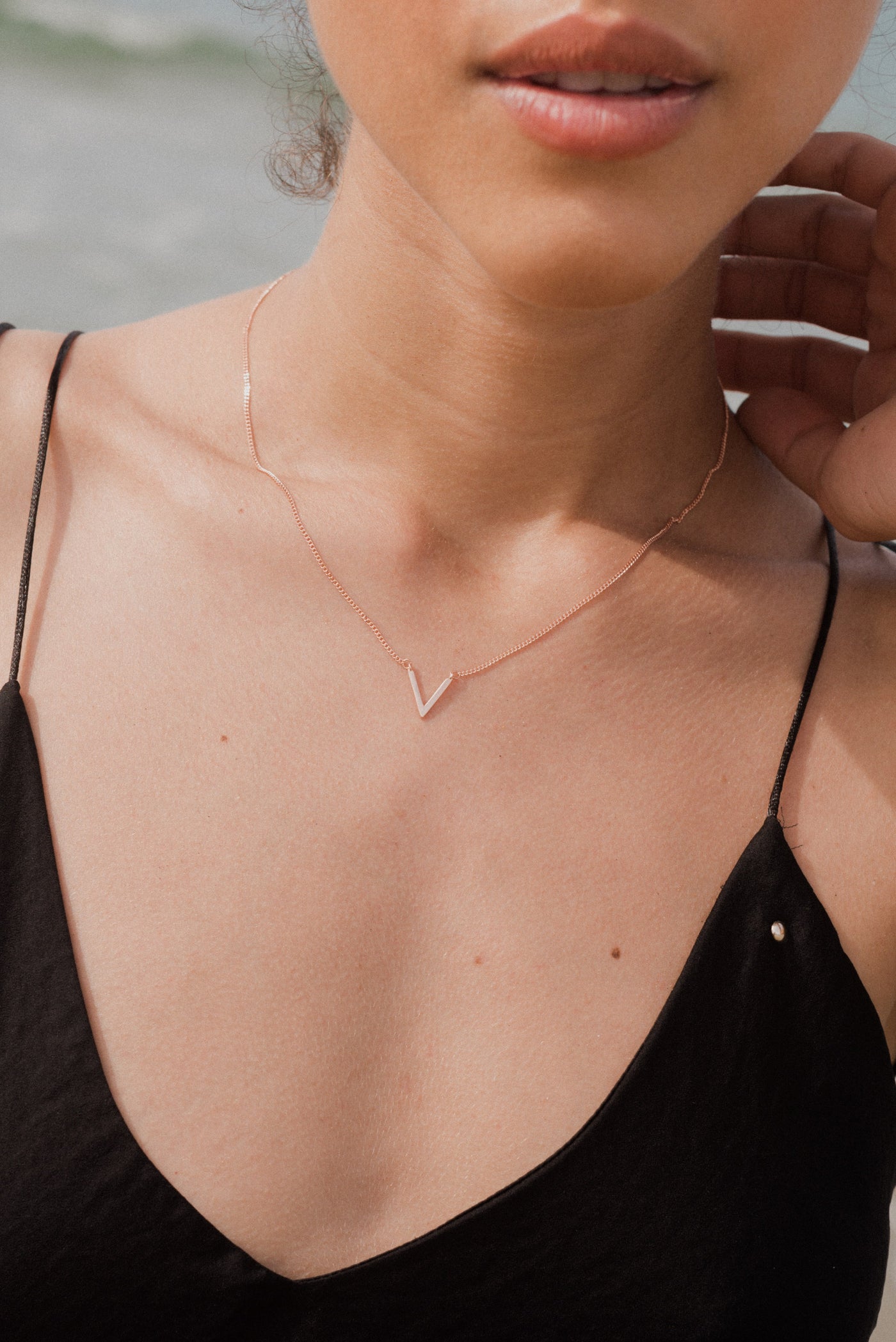 Junge Frau trägt moderne V Anhänger Kette in Rosa 