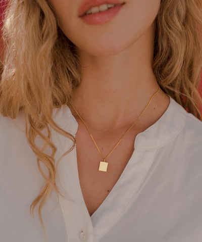 Junge Frau trägt Gold Kette mit minimalistischen Viereck Anhänger 