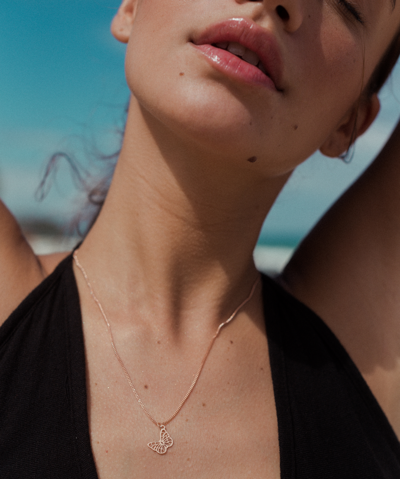 Frauen Dekolletee mit feiner Damenschmuck Kette und Schmetterling Anhänger in Rose 