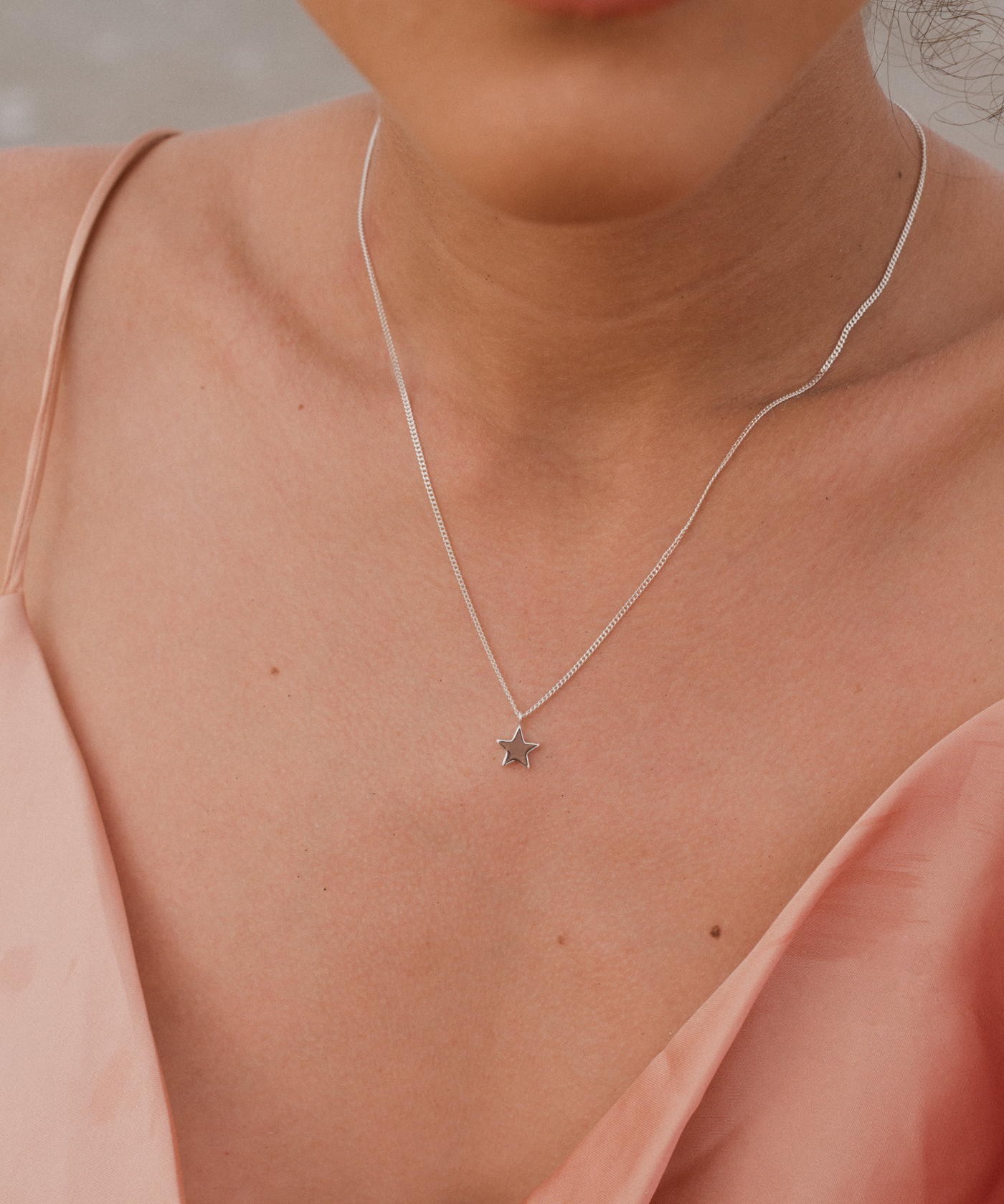 Frau trägt minimalistische Halskette mit Stern Anhänger in Sterling Silber