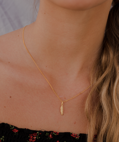 Mädchen trägt minimalistische Feder Kette in Gold 