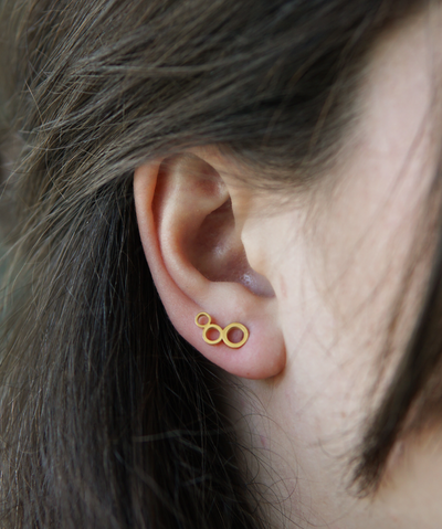 Frau trägt drei Ringe Ohrstecker in Gold aus Edelstahl 