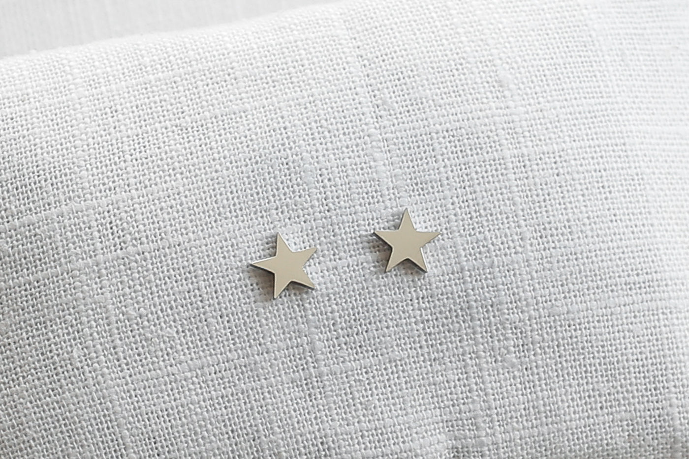 Sternen Ohrringe in Silber aus Edelstahl auf Leinen Stoff