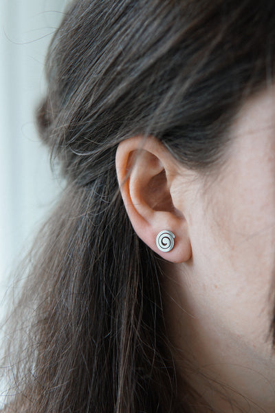 Junge Frau trägt hochwertige Ohrringe mit Spirale aus Edelstahl