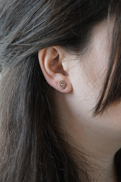 Junge Frau trägt Spiralförmige Ohrringe in Rose