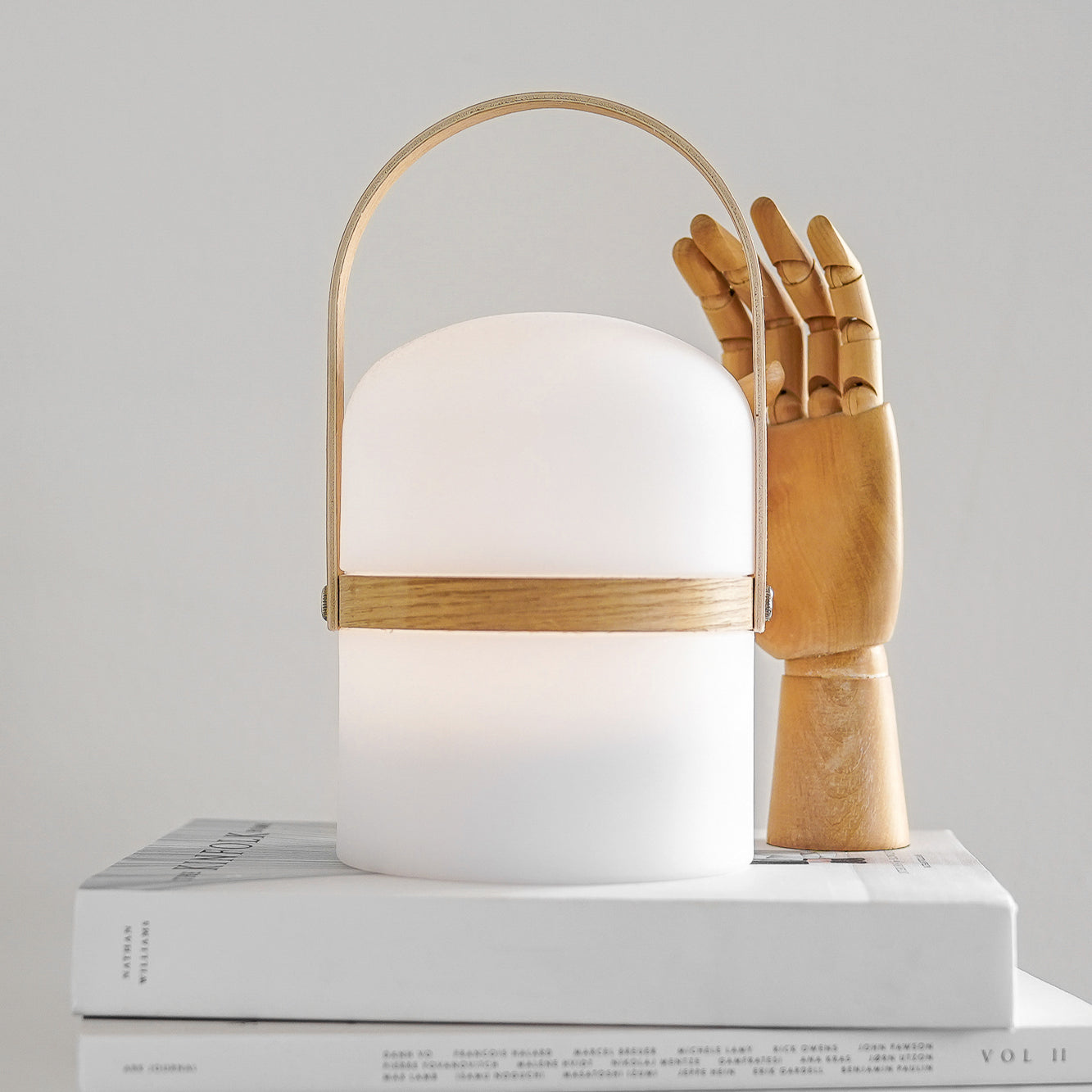 Stylische LED Laterne mit Holz Hand auf weißem Buch